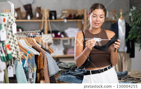 Girl customer choose high heels shoes in store 130004255