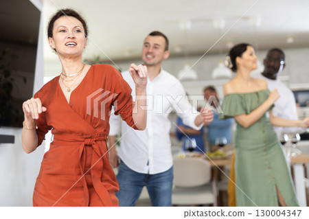 Dance moves of men and woman of different nationalities at fun holiday party at home Dance moves of men and woman of different nationalities at fun holiday party at home 130004347