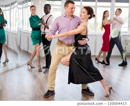 Middle-aged man and woman practicing waltz in dancing studio 130004415