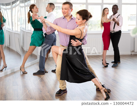 Woman dances incendiary tango with man partner during choreography lesson 130004472