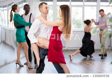 Woman dances incendiary tango with man partner during choreography lesson 130004556