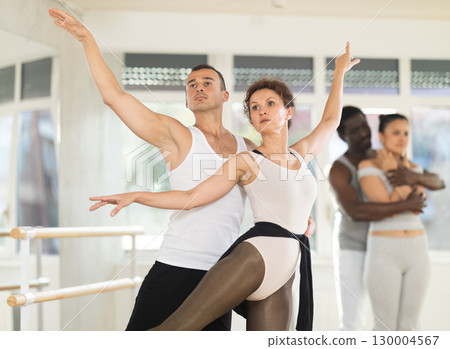 Young man and adult woman rehearsing pair ballet 130004567