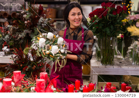 Woman in apron in christmas goods store 130004719
