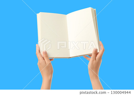 Two hands hold an open book, sparking creativity 130004944
