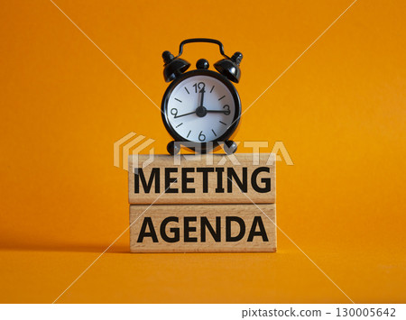 Meeting agenda symbol. Concept word Meeting agenda on wooden blocks. Beautiful orange background with alarm clock. Business and Meeting agenda concept. Copy space 130005642