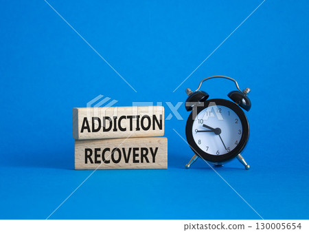 Addiction Recovery symbol. Concept words Addiction Recovery on wooden blocks. Beautiful blue background with alarm clock. Medicine and Addiction Recovery concept. Copy space. 130005654