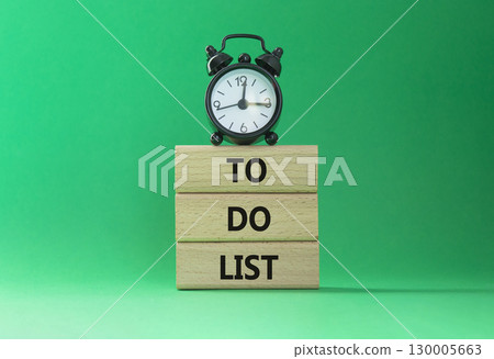 To Do List symbol. Concept words To Do List on wooden blocks. Beautiful green background with alarm clock. Business and To Do List concept. Copy space To Do List symbol. Concept words To Do List on wooden blocks. Beautiful green background with alarm clock. Business and To Do List concept. Copy space 130005663