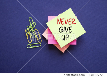 Never give up symbol. Sticky notes with Concept words Never give up. Beautiful deep blue background. Business and Never give up concept. Copy space. 130005729