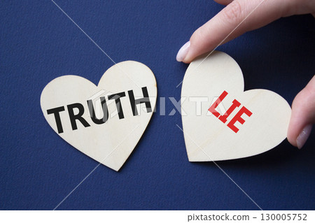 Truth or Lie symbol. Concept word Truth or Lie on wooden hearts. Businessman hand. Beautiful deep blue background. Business and Truth or Lie concept. Copy space Truth or Lie symbol. Concept word Truth or Lie on wooden hearts. Businessman hand. Beautiful deep blue background. Business and Truth or Lie concept. Copy space 130005752
