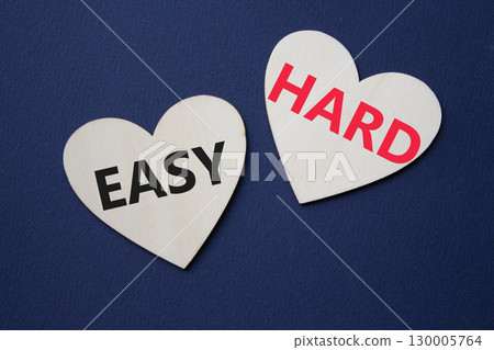 Easy or Hard symbol. Concept word Easy or Hard on wooden hearts. Beautiful deep blue background. Business and Easy or Hard concept. Copy space 130005764