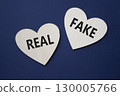 Real or Fake symbol. Concept word Real or Fake on wooden hearts. Beautiful deep blue background. Business and Real or Fake concept. Copy space 130005766
