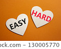 Easy or Hard symbol. Concept word Easy or Hard on wooden hearts. Beautiful orange background. Business and Easy or Hard concept. Copy space 130005770