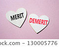 Merit or Demerit symbol. Concept word Merit or Demerit on wooden hearts. Beautiful pink background. Business and Merit or Demerit concept. Copy space 130005776