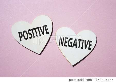 Positive or Negative symbol. Concept word Positive or Negative on wooden hearts. Beautiful pink background. Business and Positive or Negative concept. Copy space 130005777