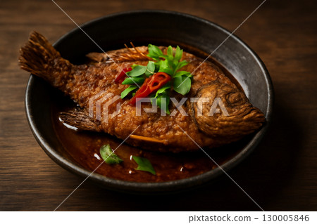 AI generated realistic close-up of a whole crispy fried fish in a rustic bowl. The warm tones and fresh ingredients evoke a sense of comfort, tradition, and the inviting essence of Thai cuisine. 130005846