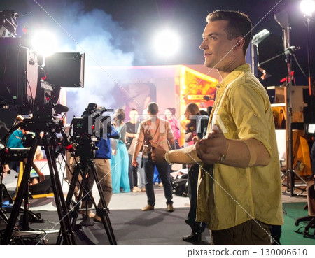 AI generated A visionary film director stands at the frame edge gesturing toward a busy movie set with cameras and crew. The dynamic scene captures the creative energy of filmmaking, storytelling AI generated A visionary film director stands at the frame edge gesturing toward a busy movie set with cameras and crew. The dynamic scene captures the creative energy of filmmaking, storytelling 130006610