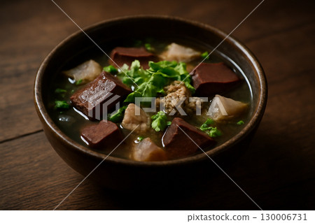 AI generated vibrant image of Thai pork blood soup served in a rustic wooden bowl. The rich textures and earthy tones emphasize the authenticity and warmth of traditional Thai cuisine. 130006731