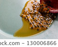 Half a passion fruit on a plate with fruit and juice spilling out 130006866