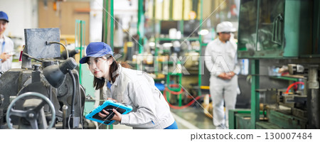 A male worker showing a visitor around the factory 130007484