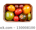 Fresh and ripe tomatoes of various varieties, colors, and sizes in a cardboard punnet. Varieties of the plant Solanum lycopersicum, whose fruits are edible berries and are eaten as vegetables. Photo 130008100