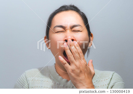 Asian woman yawning and covering mouth Asian woman yawning and covering mouth 130008419