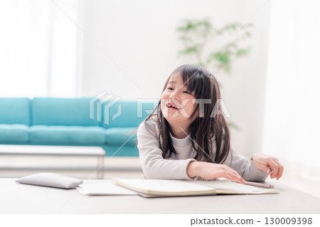 一名小學低年級的女孩獨自在家做作業 130009398