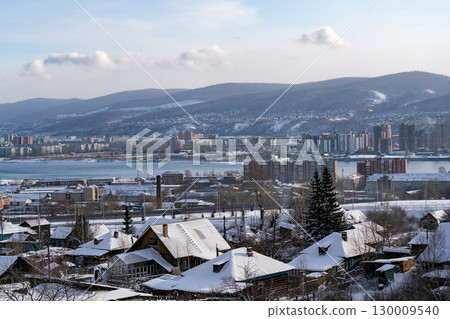 Industrial city on the river in winter against a cloudy sky. 130009540