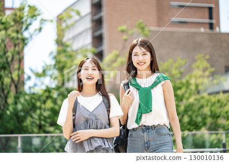 一位女大學生在校園散步，和朋友開心地聊天 130010136