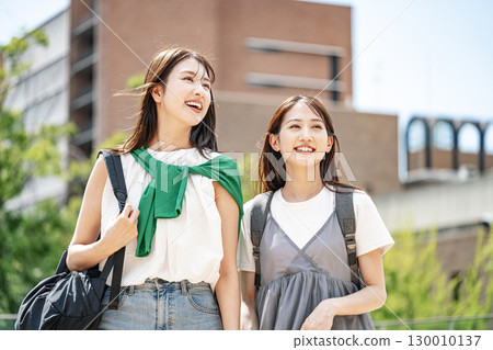 A female college student walking around the campus, chatting happily with her friends 130010137