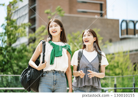 A female college student walking around the campus, chatting happily with her friends 130010155