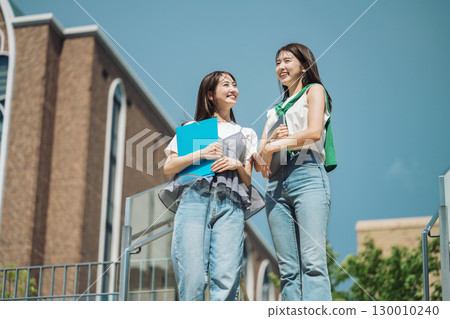 一位女大學生在校園散步，和朋友開心地聊天 130010240