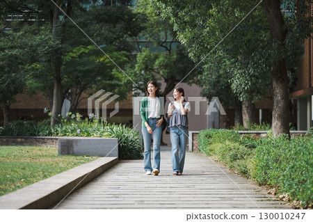 College students walking and talking with friends 130010247