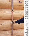 The construction site of a wooden house. Traditional log cabin built from wood logs on sunny summer day. Cottage house design 130011109