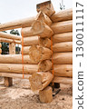 The construction site of a wooden house. Traditional log cabin built from wood logs on sunny summer day. Cottage house design 130011117