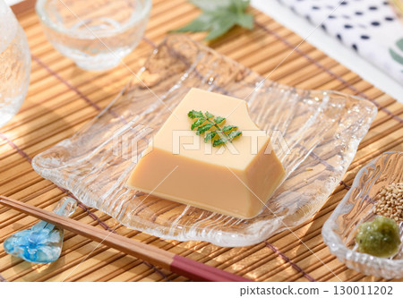 清爽夏日日式料理：雞蛋豆腐和佐料盛放在透明玻璃盤中。清爽優雅的菜餚形象。 130011202