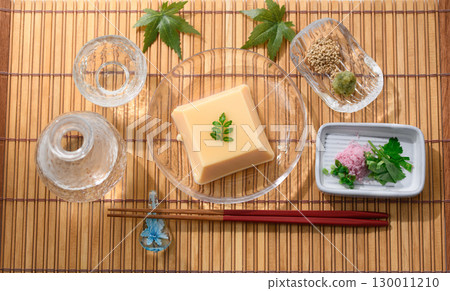 清爽夏日日式料理:雞蛋豆腐和佐料盛放在透明玻璃盤中。清爽優雅的菜餚形象。 清爽夏日日式料理:雞蛋豆腐和佐料盛放在透明玻璃盤中。清爽優雅的菜餚形象。 130011210