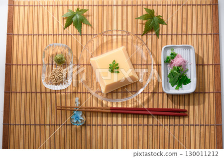 清爽夏日日式料理:雞蛋豆腐和佐料盛放在透明玻璃盤中。清爽優雅的菜餚形象。 清爽夏日日式料理:雞蛋豆腐和佐料盛放在透明玻璃盤中。清爽優雅的菜餚形象。 130011212
