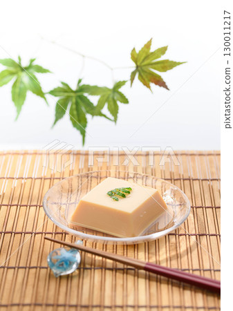 清爽夏日日式料理:雞蛋豆腐和佐料盛放在透明玻璃盤中。清爽優雅的菜餚形象。 清爽夏日日式料理:雞蛋豆腐和佐料盛放在透明玻璃盤中。清爽優雅的菜餚形象。 130011217