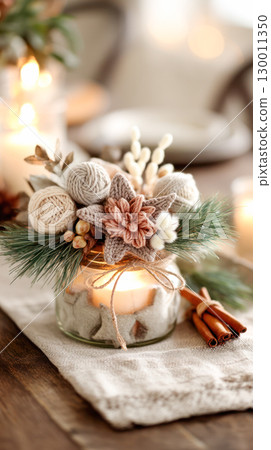 Decorative candle jar adorned with knitted flowers and pine branches, creating a cozy atmosphere for seasonal celebrations and home decor 130011350