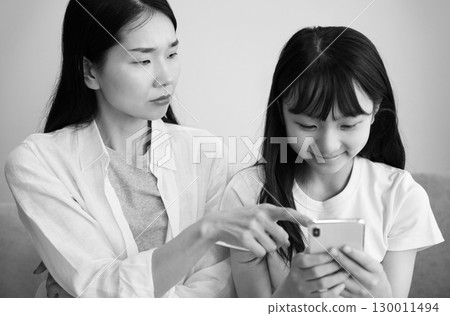 一位母親責罵沉迷於智慧型手機的女兒的圖片 130011494