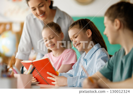 Happy kids and teacher at school Happy kids and teacher at school 130012324