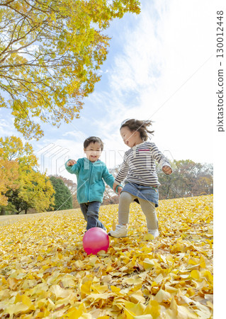 一個男孩和一個女孩在黃葉公園玩耍 130012448