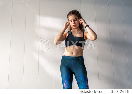Woman in fashionable sportswear is doing exercise. Woman in fashionable sportswear is doing exercise. 130012616