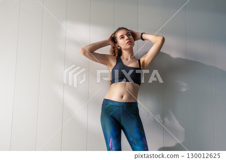 Woman in fashionable sportswear is doing exercise. Woman in fashionable sportswear is doing exercise. 130012625