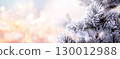 Horizontal Christmas background with pine branch, covered with frost. Holiday winter banner with frozen branches of fir tree. Festive banner featuring a frosted fir branch at abstract glitter lights 130012988