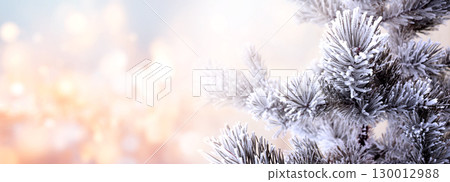 Horizontal Christmas background with pine branch, covered with frost. Holiday winter banner with frozen branches of fir tree. Festive banner featuring a frosted fir branch at abstract glitter lights Horizontal Christmas background with pine branch, covered with frost. Holiday winter banner with frozen branches of fir tree. Festive banner featuring a frosted fir branch at abstract glitter lights 130012988