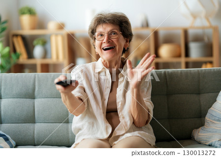Senior woman watching TV 130013272