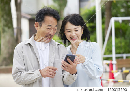 中年夫婦在戶外使用智慧型手機 130013590