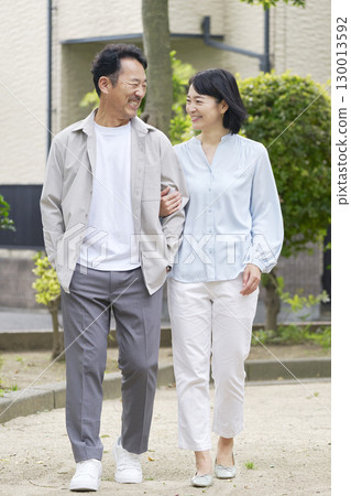 中年夫婦在戶外手挽手散步，全身 130013592