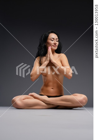 Beauty woman poses gracefully in studio setting during serene moment Beauty woman poses gracefully in studio setting during serene moment 130013958